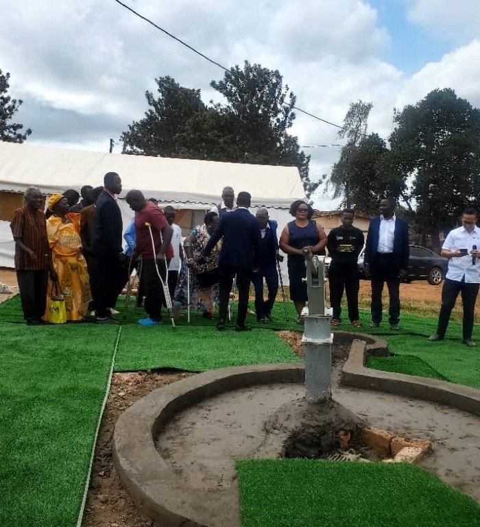 KPDDI's compound in Kireka with the new borehole water pump, community members gathered behind it